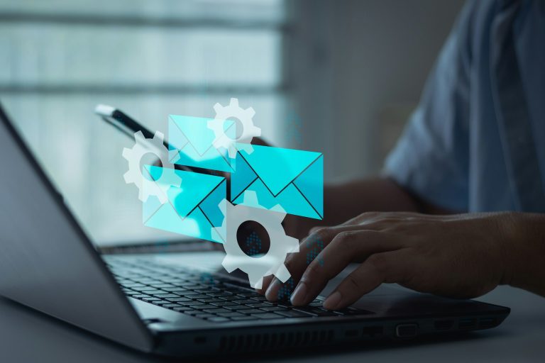 Person using laptop with workflow automation gear icons