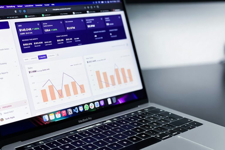 Laptop displaying Power BI reporting and analytics dashboard
